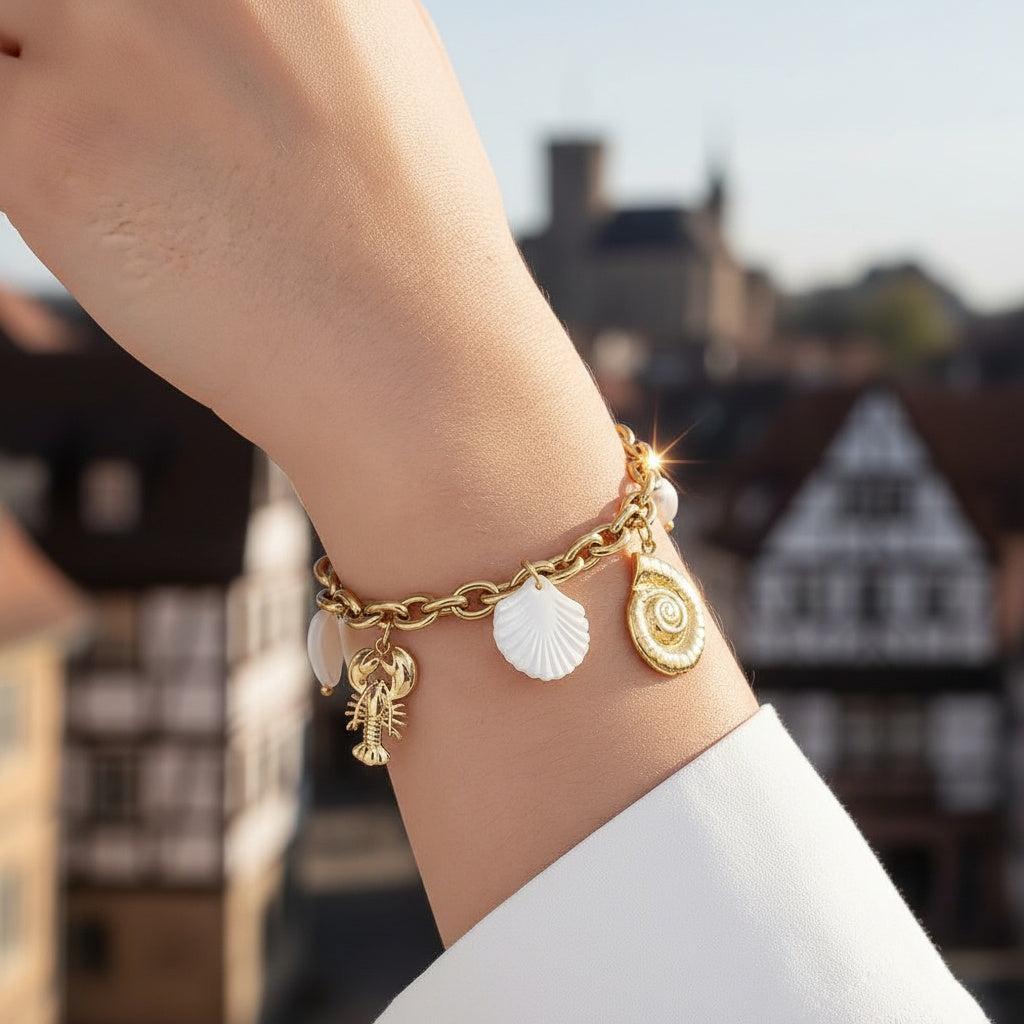 „Coralia“ – Edelstahl-Arm­kette mit Muschel- & Süßwasser­perlen-Charms, 19 cm