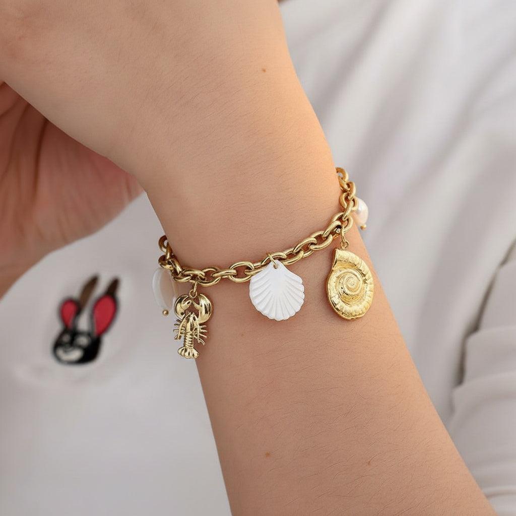 „Coralia“ – Edelstahl-Arm­kette mit Muschel- & Süßwasser­perlen-Charms, 19 cm