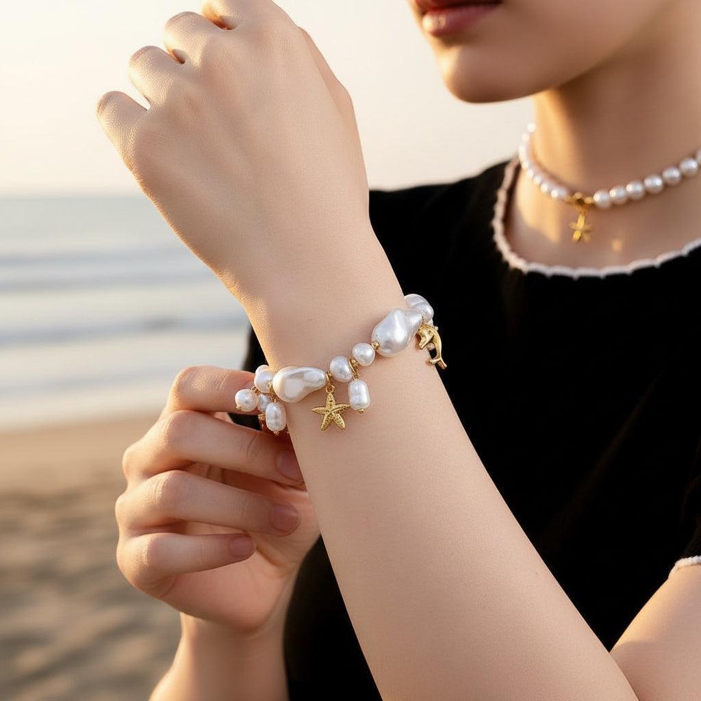 „Marilou“ – Edelstahl-Arm­kette mit Ocean-Charms & barocker Kunstperle, 20 cm