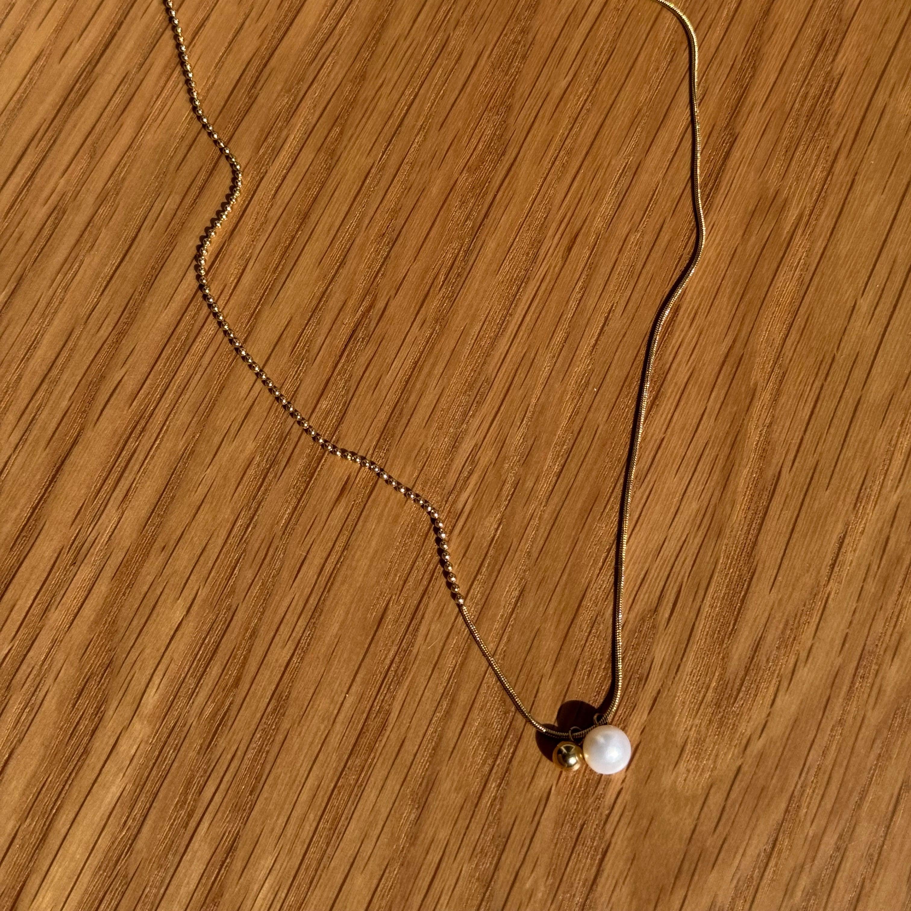 "Rana" – Goldfarbene Halskette mit Süßwasserperle & Kugelanhänger (42+5 cm)