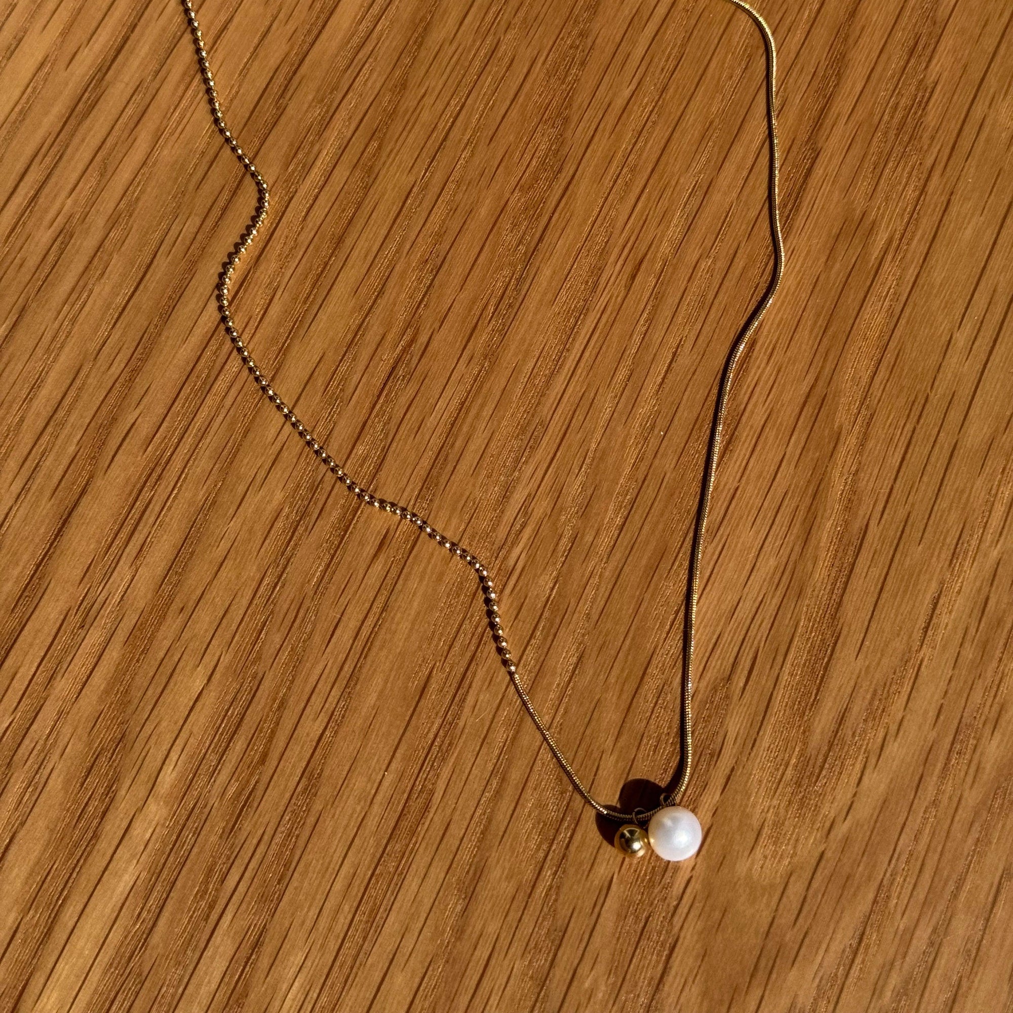 "Rana" – Goldfarbene Halskette mit Süßwasserperle & Kugelanhänger (42+5 cm)